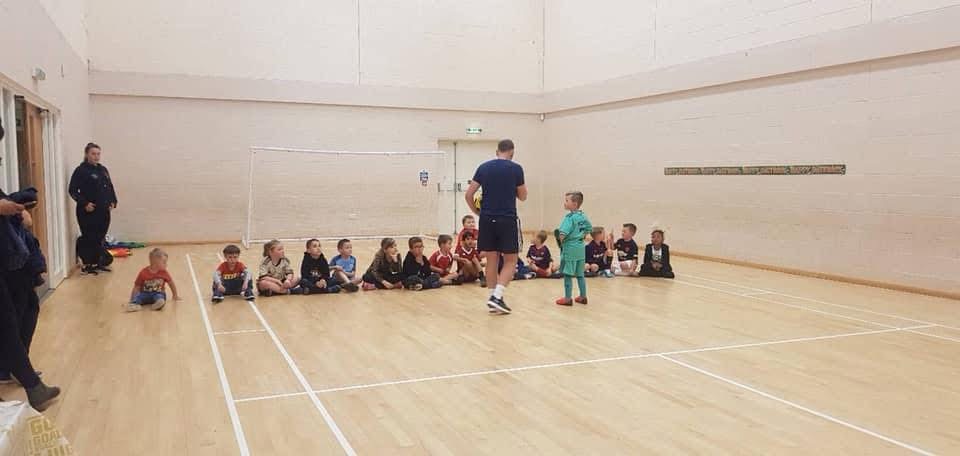 Coach awarding medal to child during session